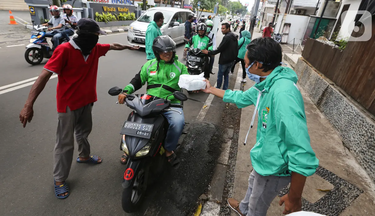 Ojek online (ojol) menerima bantuan berupa bingkisan makan siang dan hand sanitizer di kawasan Jalan Raden Saleh, Jakarta, Selasa (7/3/2020). Bantuan dari DPP PKB guna meringankan beban ojol yang sepi orderan akibat lesunya perekonomian selama pandemi corona Covid-19. (Liputan6.com/Fery Pradolo)