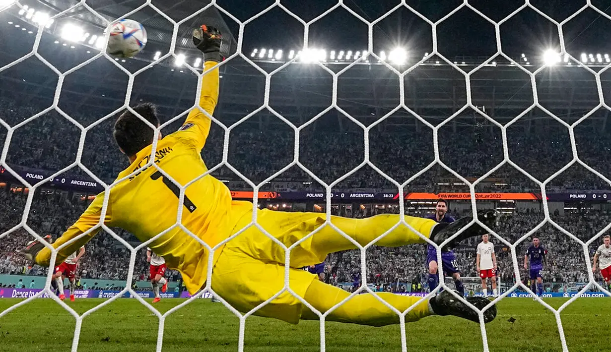 Penjaga gawang Polandia Wojciech Szczesny menyelamatkan tendangan penalti pemain Argentina Lionel Messi pada pertandingan sepak bola Grup C Piala Dunia 2022 di Stadion 974, Doha, Qatar, 30 November 2022. Argentina lolos ke babak 16 besar Piala Dunia 2022 dengan status juara Grup C usai mengalahkan Polandia 2-0. (AP Photo/Ariel Schalit)