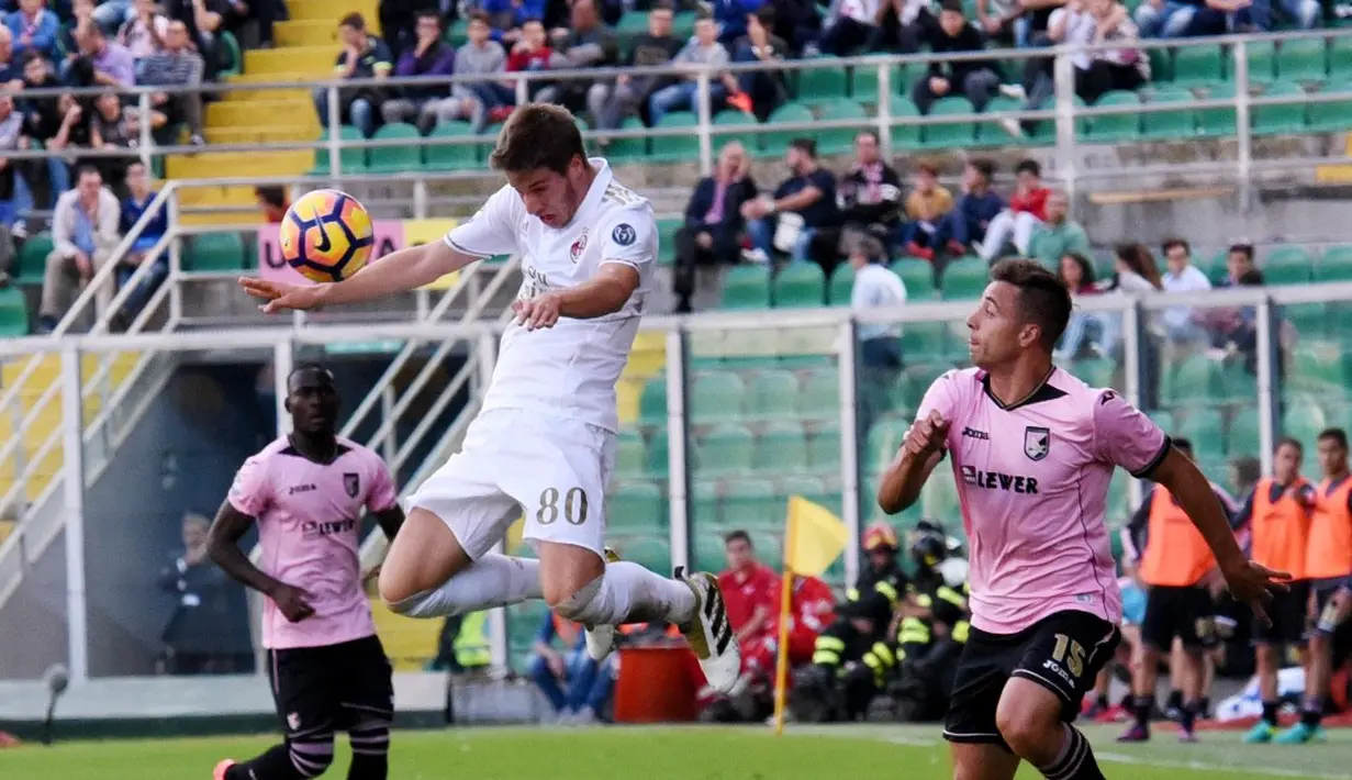 Pemain AC Milan, Mario Pasalic, berusaha menghalau bola dari pemain Palermo dalam laga pekan ke-12 Serie A di Stadion Renzo Barbera, Minggu (6/11/2016). (AFP)