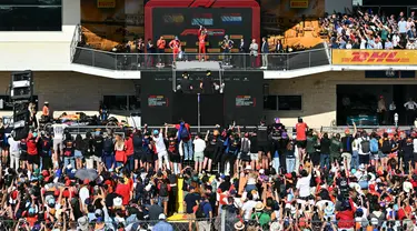 Penonton dan penggemar bersorak saat menyaksikan upacara podium kemenangan Grand Prix Formula 1 Amerika Serikat di Circuit of the Americas di Austin, Texas, pada 20 Oktober 2024. (ANGELA WEISS/AFP)