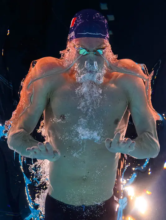 Pemandangan bawah air menunjukkan Leon Marchand dari Prancis yang berkompetisi di final renang gaya ganti perorangan 400 meter putra selama Olimpiade Paris 2024 di Paris La Defense Arena di Nanterre, pada 28 Juli 2024. (FranÁois-Xavier MARIT/AFP)