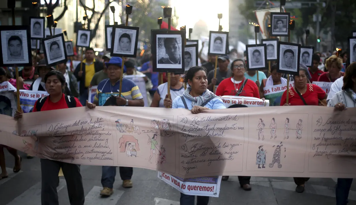 Keluarga dari 43 mahasiswa Meksiko yang menghilang melakukan long march di jalanan Meksiko City, Selasa (26/4).Pada peringatan 19 bulan, mereka mendesak pemerintah menginvestigasi lebih lanjut kasus hilangnya para mahasiswa itu. (REUTERS/Edgard Garrido)
