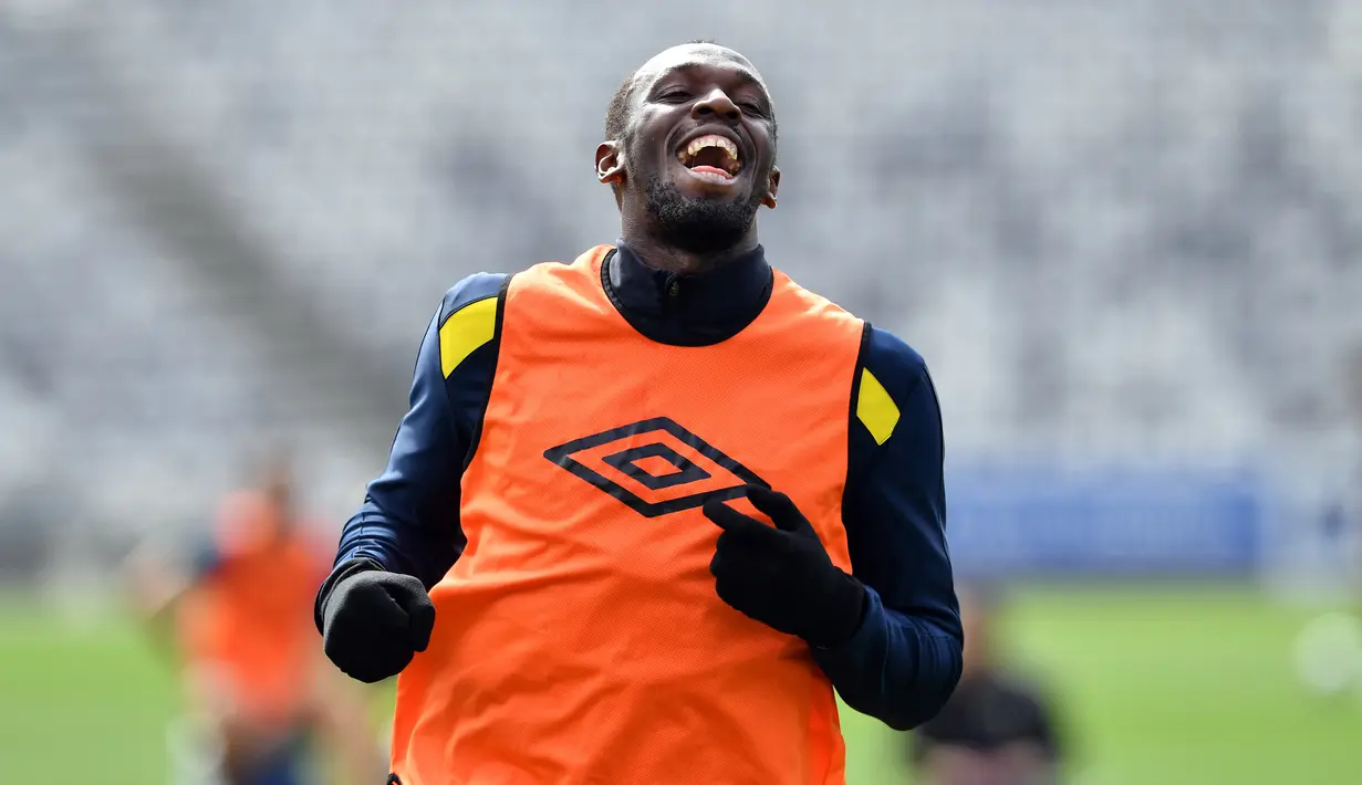 Pelari tercepat dunia, Usain Bolt tertawa saat mengikuti latihan di Central Coast Stadium, Gosford, Australia, (21/8). Bolt akan memulai debutnya di sepak bola Australia dengan bermain untuk Central Coast Mariners. (AFP Photo/Saeed Khan)