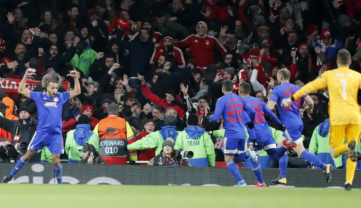 Pemain Olympiakos, Youssef El-Arabi (kiri) berselebrasi usai mencetak gol ke gawang Arsenal pada leg kedua babak 32 besar Liga Europa di stadion Emirates, London, Kamis (27/2/2020).  Olympiakos menang 2-1 dan lolos dengan unggul agregat gol tandang 2-2. (AP Photo/Frank Augstein)