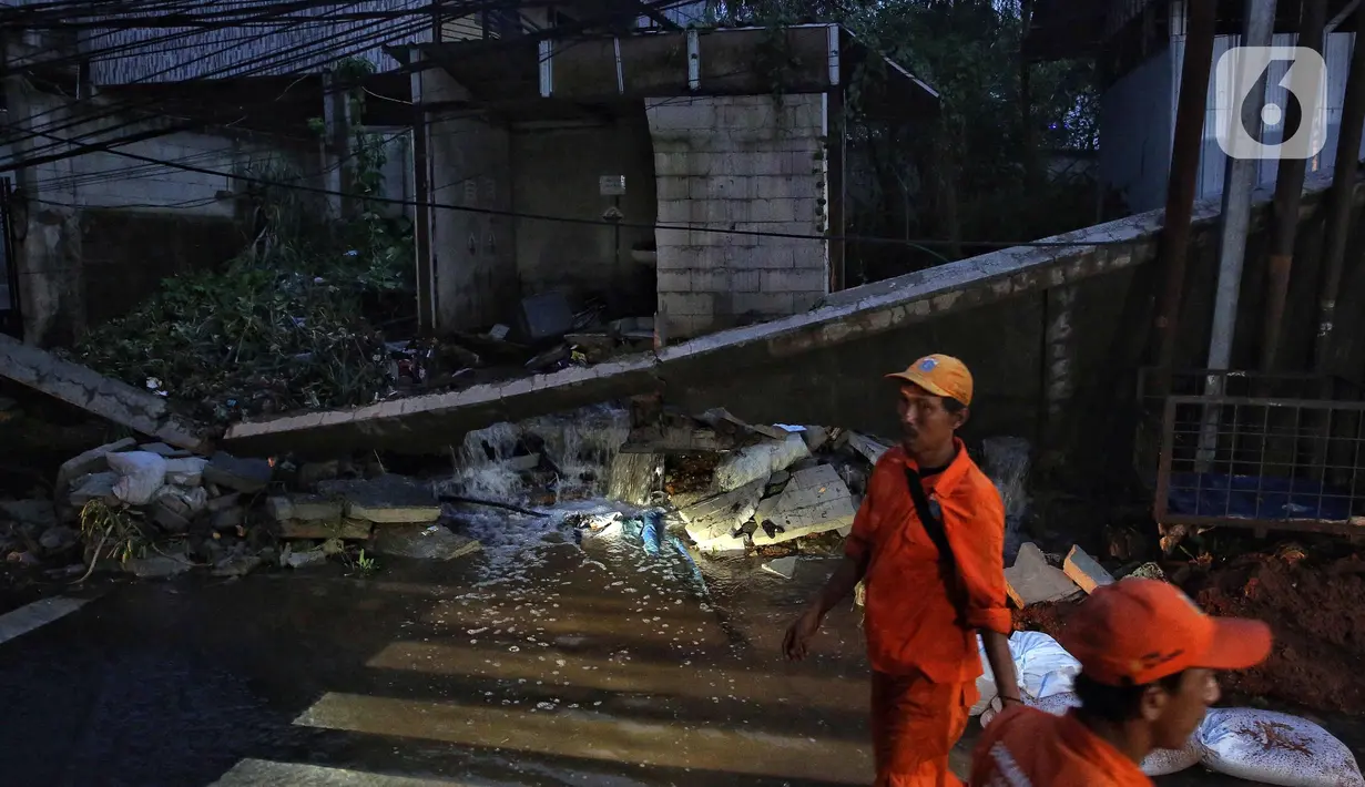 Luapan air menggerus pondasi yang robohnya sebuah pagar tembok. (Liputan6.com/Angga Yuniar)