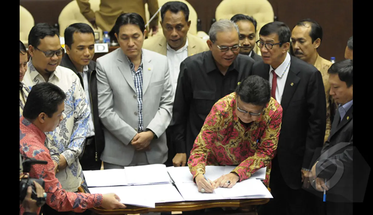 Mendagri Tjahjo Kumolo menandatangani Perppu Pilkada dalam rapat kerja bersama Komisi II DPR di Gedung Nusantara, Kompleks Parlemen Senayan, Jakarta, Senin (19/1/2015). (Liputan6.com/Andrian M Tunay)