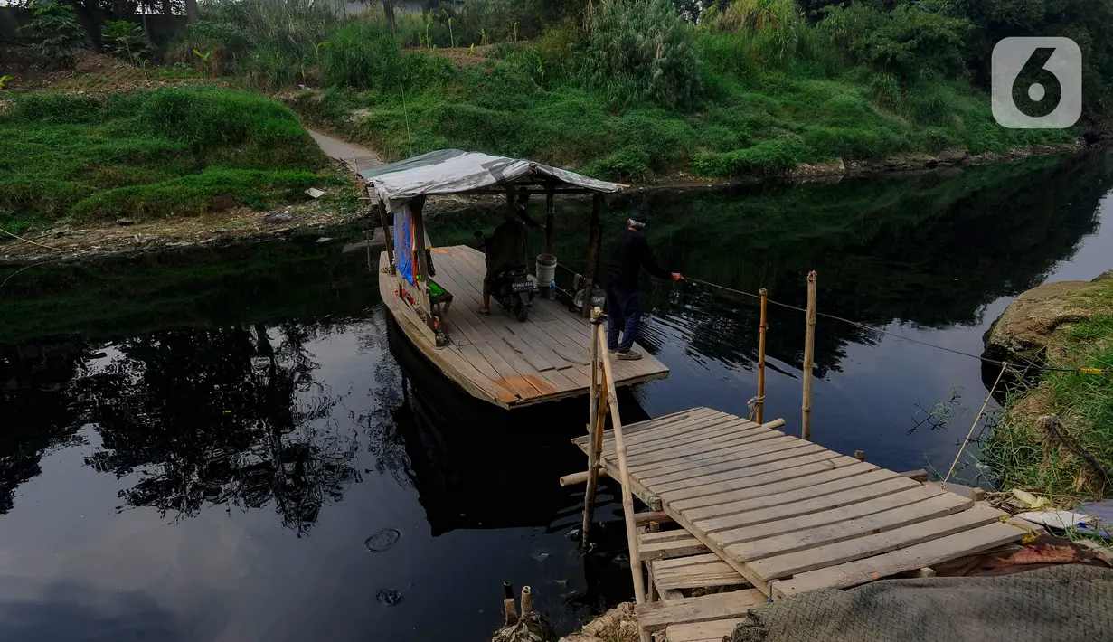 Warga menggunakan perahu eretan di sungai yang tercemar limbah pabrik di kawasan Angsana, Gunung Putri, Bogor, Minggu (27/08/2023). (merdeka.com/Arie Basuki)