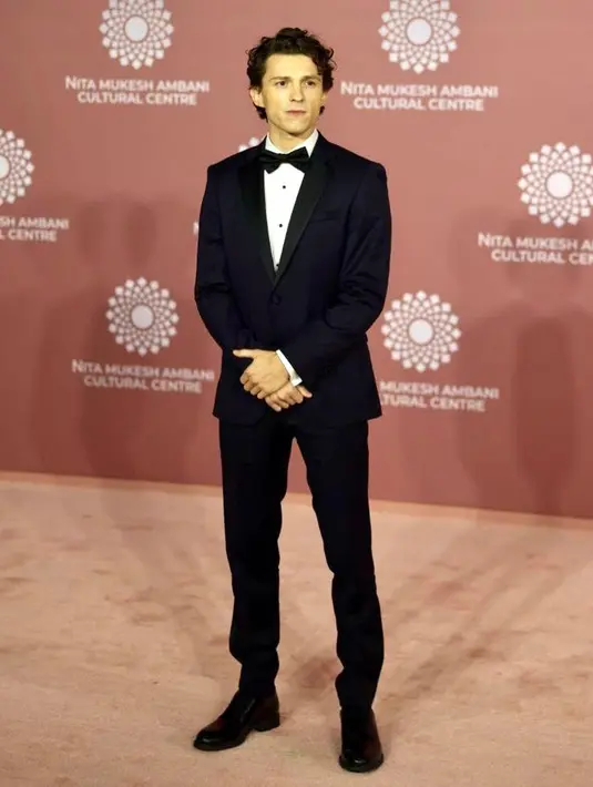 Hadir pula Tom Holland yang tampil necis dalam balutan setelan jas warna hitam.  [Foto: IG/vogueindia].