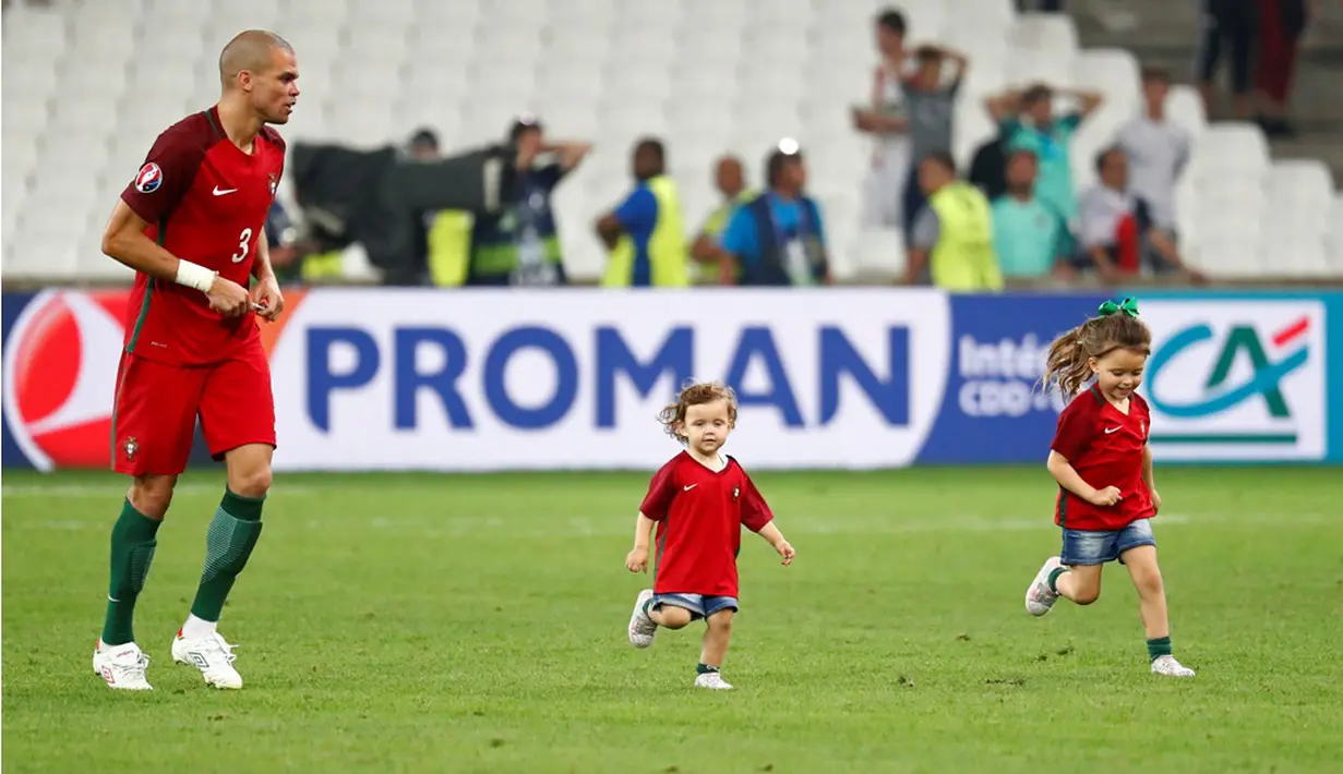 Bek Portugal, Pepe, bercanda dengan anak-anaknya setelah menang adu penalti melawan Polandia pada laga perempat final Piala Eropa 2016 di Stade Velodrome, Marseille, Jumat (1/7/2016) dini hari WIB. (Reuters/Michael Dalder)