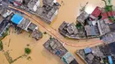Foto ini menunjukkan pemandangan udara dari orang-orang yang melintasi jalan setapak yang dibangun di atas air banjir di sebuah jalan di kota Maying di Jiujiang, di provinsi Jiangxi Tengah, China, pada 3 Juli 2024. (Foto: AFP)