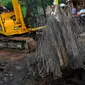 Alat berat mengangkat besi Jembatan Inspeksi Kali Grogol yang ambles di Komplek Hankam, Slipi, Jakarta, Senin (21/3). Dinas Pemprov DKI sedang melakukan perbaikan di kawasan depan Komplek HANKAM slipi Jakarta Barat. (Liputan6.com/Faisal R Syam)