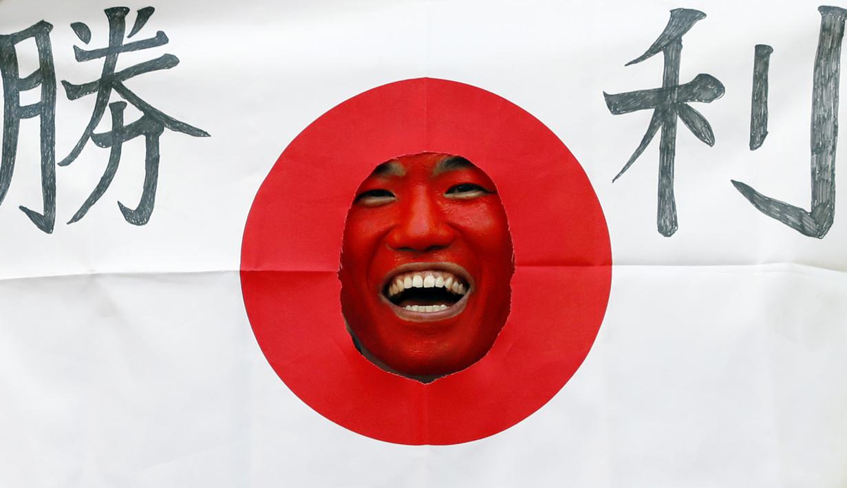 Suporter Jepang beraksi saat menonton negaranya melawan Kolombia pada laga grup H Piala Dunia di Mordovia Arena, Saransk, Selasa (19/6/2018). (AFP/Jack Guez)