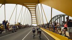 Para pebalap sedang melewati sebuah jembatan di Etape 2 Tour de France yang berjarak 166 km antara Utrecht dan Vrouwenpolder, Belanda. (5/7/2015). (AFP PHOTO/LIONEL BONAVENTURE)
