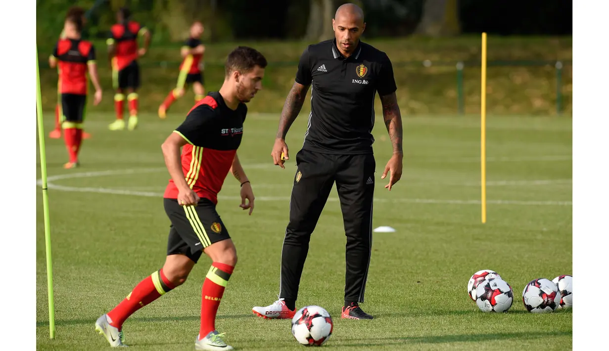 Thierry Henry  mengawasi Eden Hazard berlatih pada sesi latihan sebelum melawan Spanyol di Neerpede, (29/8/2016). (AFP/John Thys)