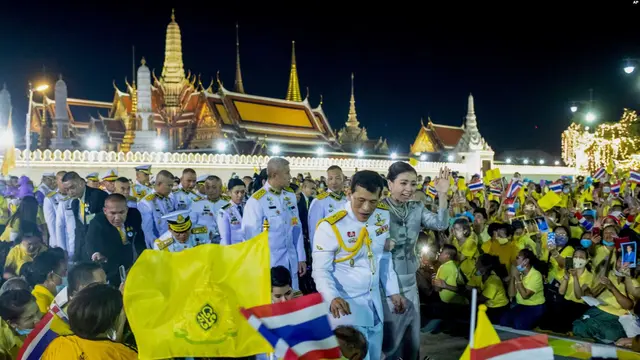 Raja Thailand Maha Vajiralongkorn (tengah kiri) dan Ratu Suthida (tengah kanan), melambaikan tangan ke arah para demonstran di Bangkok, Thailand, Minggu, 1 November 2020. (AP)