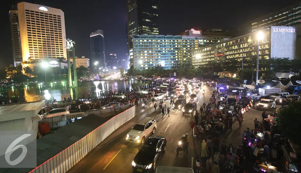 Warga memadati kawasan Bundaran HI di Jakarta, Sabtu (31/12). Jelang pergantian tahun, kawasan tersebut mulai dipadati warga dari berbagai daerah, meskipun tidak diberlakukan car free night. (Liputan6.com/Immanuel Antonius)