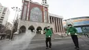 Pekerja memakai masker menyemprotkan disinfektan sebagai tindakan pencegahan virus corona COVID-19 di depan Katedral Myeongdong di Korea Selatan, Rabu, (26/2/2020). Total kasus Virus Corona COVID-19 Korea Selatan melonjak menjadi empat angka pada Rabu 26 Februari 2020. (Yun Dong-jin/Yonhap via AP)