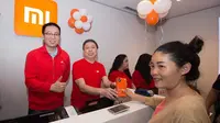 Head of Xiaomi South Pacific Region Steven Shi and Xiaomi Indonesia Country Manager (kiri) bersama Hasan Aula, CEO Erajaya Group melayani beberapa pelanggan pertama yang hadir pada pembukaan Mi Store MKG (Foto: Dok Xiaomi Indonesia)