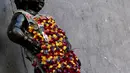 Gambar pada 12 Agustus 2019 memperlihatkan patung 'Manneken Pis' dalam balutan baju bermotif bunga di ibu kota Belgia, Brussels, Senin (12/8/2019). Patung perunggu yang hanya berukuran 60 sentimeter ini berwujud bocah lelaki yang sedang buang air kecil. (Photo by Kenzo TRIBOUILLARD / AFP)