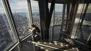 Seorang wanita mengabadikan suasana Kota Manhattan dari ruangan observatorium di lantai 102 Gedung Empire State yang baru direnovasi di New York (10/10/2019). Dibuka untuk umum pada 12 Oktober, ruang observatorium ini berjarak 1.250 kaki di atas permukaan jalan. (AFP Photo/Drew Angerer)