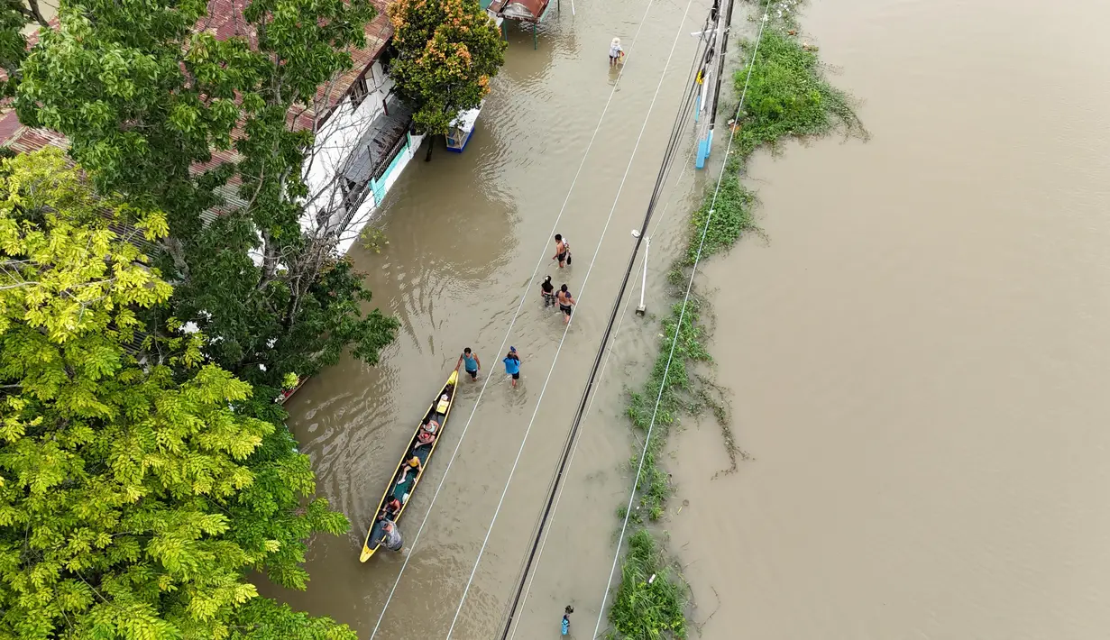 Tim penyelamat di Filipina utara melakukan evakuasi dengan menjemput warga yang terdampar akibat banjir dan mengirimkan pasokan dengan perahu. (Ted ALJIBE/AFP)