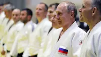 Presiden Rusia, Vladimir Putin mengambil bagian dalam sesi latihan judo bersama atlet nasional Rusia di Sochi, Kamis (14/2). Judo merupakan salah satu olahraga kegemaran Putin yang telah digeluti sejak masa muda. (Mikhail KLIMENTYEV/SPUTNIK/AFP)