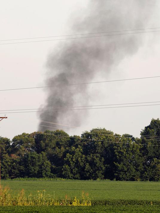 Asap mengepul dari lokasi jatuhnya sebuah pesawat militer milik Amerika Serikat (AS) di jalur county Sunflower-Leflore, negara bagian Mississippi, Senin (10/7). Setidaknya lima orang tewas dalam insiden ini. (AP Photo/Andy Lo)