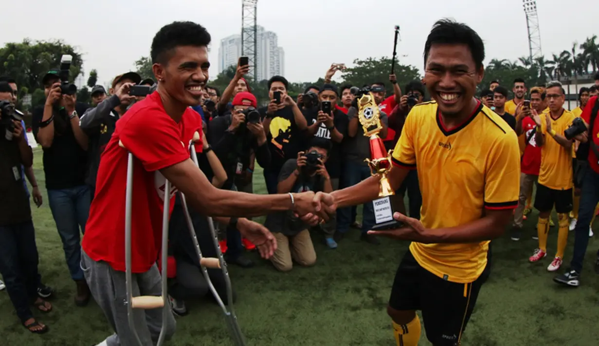 Alfin Tuasalamony menyerahkan piala kepada Tony Sucipto yang mewakili tim Specs yang menjadi juara Trofeo Charity Match. (Bola.com/Arief Bagus)