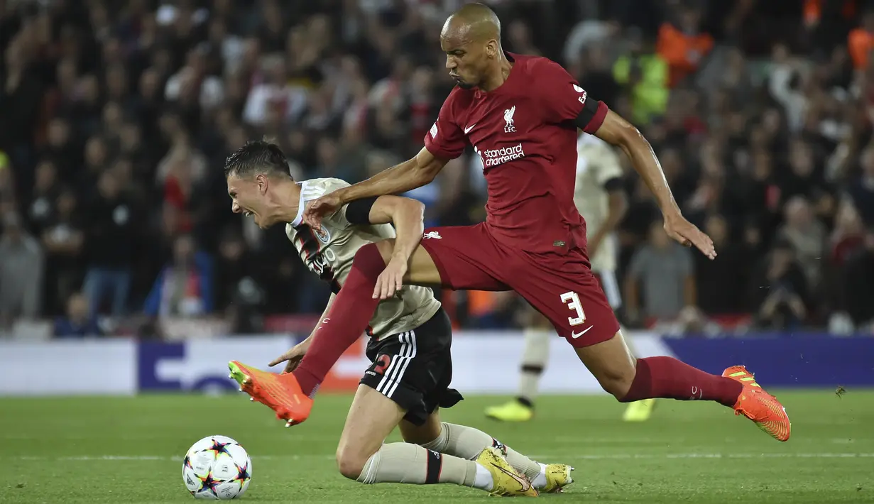 Penyerang Ajax Amsterdam Steven Berghuis berebut bola dengan gelandang Liverpool Fabinho pada pertandingan kedua Grup A Liga Champions 2022/2023 di Stadion Anfield, Rabu (14/9/2022) dini hari WIB. Liverpool menang susah payah saat menjamu Ajax berkat gol menit akhir bek Joel Matip. (AP Photo/Rui Vieira)