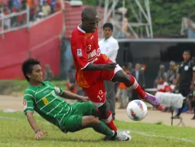 Pemain Semen Padang FC Joshua Pahabol (kanan) dihadang pemain Persebaya 1927 Taufiq saat menggiring bola pada pertandingan lanjutan Liga Prima Indonesia Sportindo di Staion H.Agus Salim Padang, Sumbar, Sabtu (14/4). Dalam pertandingan tersebut Semen Padang FC menang tipis dari lawannya dengan skor akhir 2-1. (Antara)