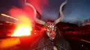 Seorang pria berpakaian seperti Krampus, mahkluk setengah kambing dan setengah iblis, dalam sebuah acara di Boerwang, 24 November 2018. Krampus merupakan legenda tradisi Natal di Jerman untuk menakuti anak-anak yang nakal. (KARL-JOSEF HILDENBRAND/DPA/AFP)