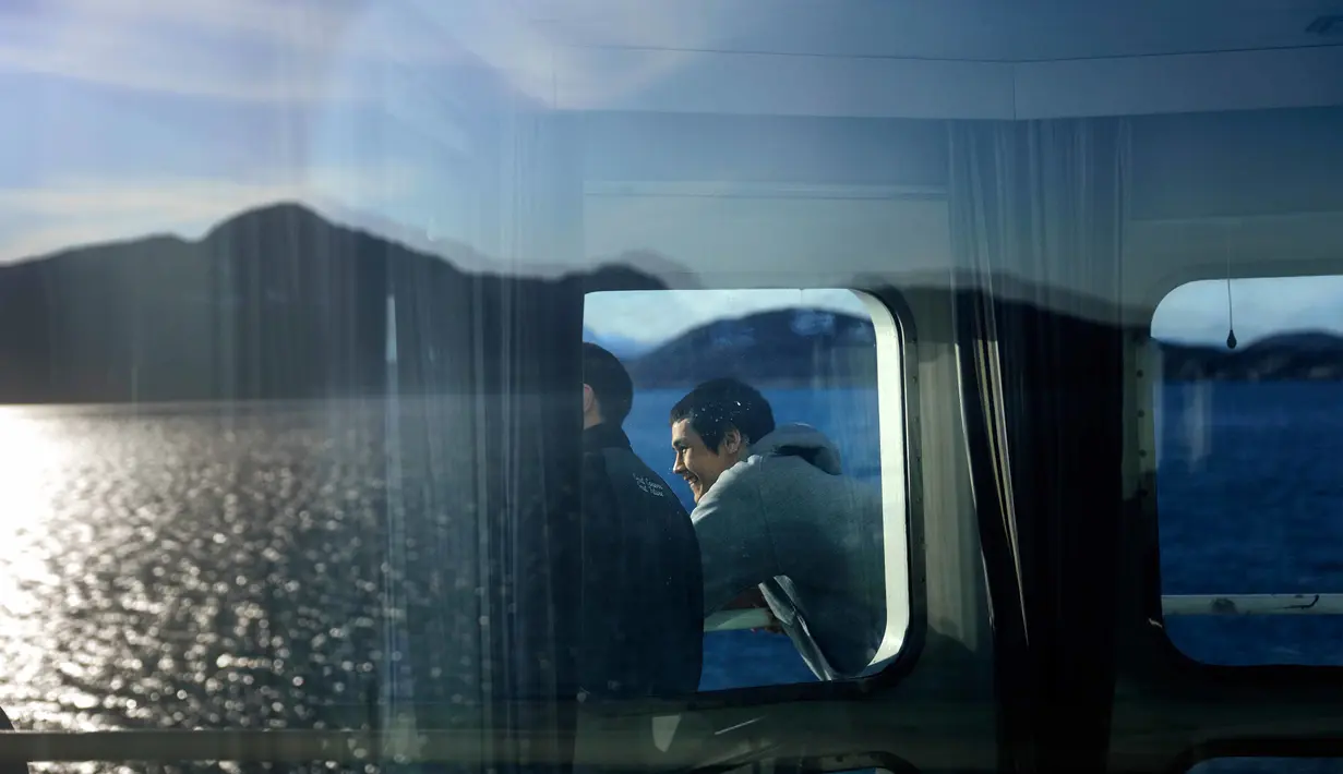 David Kullualik melihat pemandangan dari atas kapal pemecah es Finlandia MSV Nordica saat tiba di Nuuk, Greenland (29/7). (AP Photo/David Goldman)