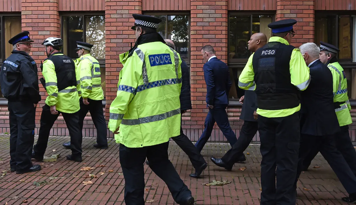 Petugas polisi mengawal Penyerang Everton Wayne Rooney di pengadilan Stockport Magpenrates di Stockport, Inggris (18/9). Polisi menangkap Rooney ketika mengemudikan mobil VW Hitam sambil mabuk di Wilmslow. (AFP Photo/Paul Ellis)