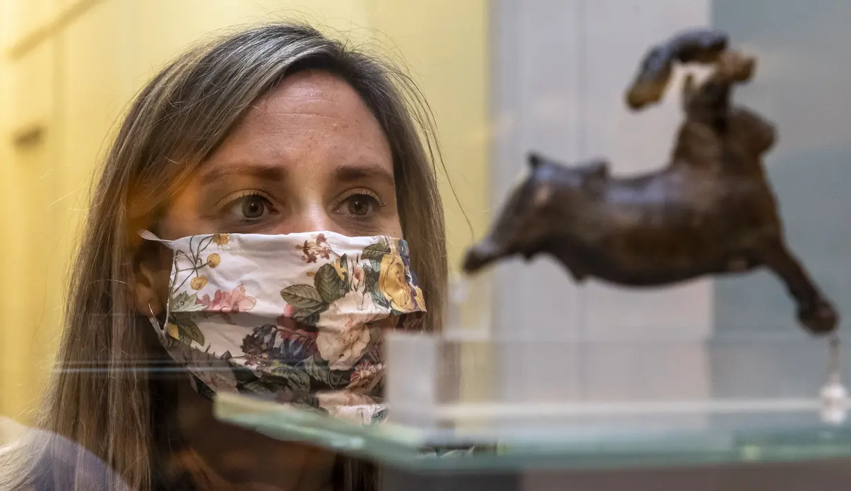 Seorang staf mengamati sebuah benda pameran saat pratinjau media menjelang pembukaan kembali Museum Inggris di London, Inggris (25/8/2020). Museum tersebut akan dibuka kembali pada 27 Agustus. (Xinhua/Han Yan)