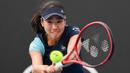 Petenis Jepang, Nao Hibino, memukul bola saat melawan petenis Yunani, Maria Sakkari, pada laga Australia Open di Melbourne, Selasa (21/1). (AFP/Manan Vatsyayana)
