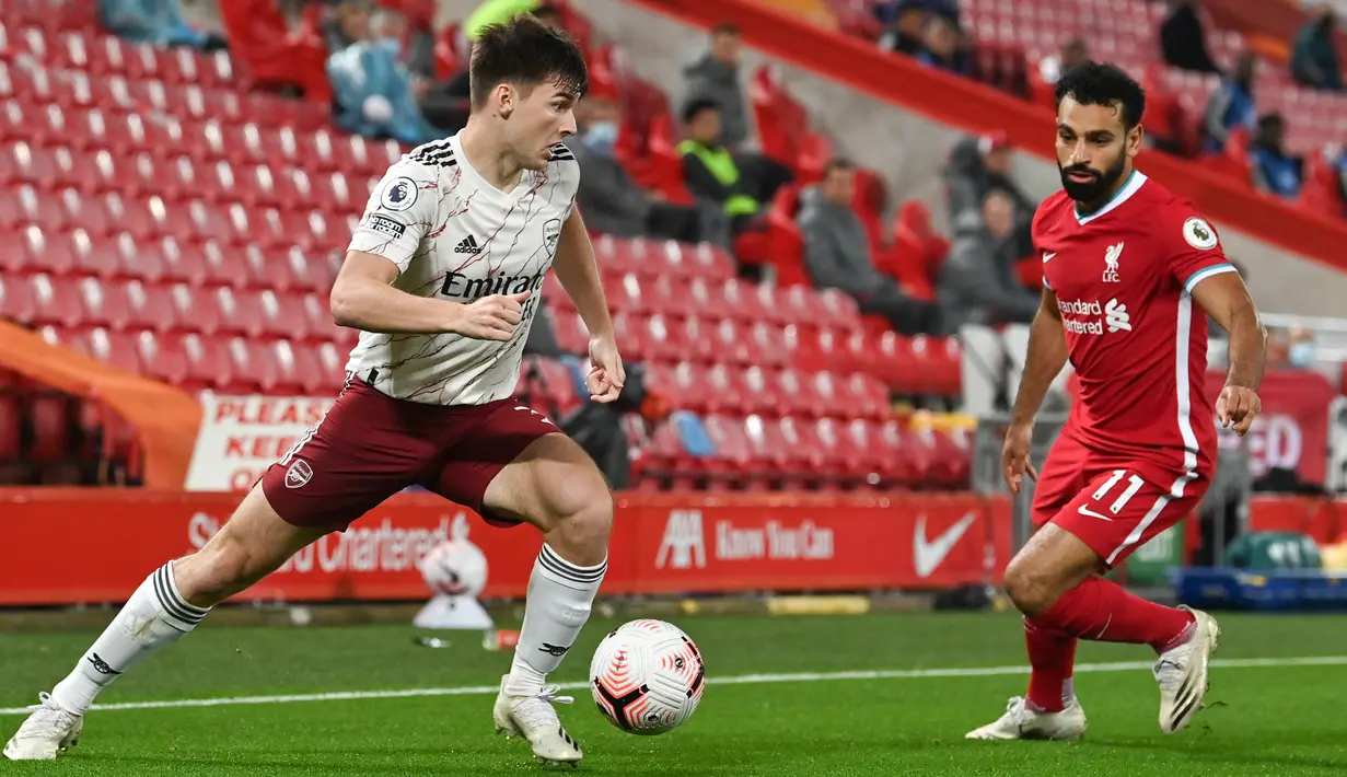 Bek Arsenal, Kieran Tierney menggiring bola melewati pemain penyerang Liverpool, Mohamed Salah pada pekan ketiga Liga Inggris di Anfield, Selasa dinihari WIB (29/9/2020). Tertinggal lebih dulu, Liverpool mampu membungkam Arsenal dengan skor 3-1. (Paul Ellis / Pool via AP)