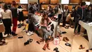 Calon pembeli menjajal sepatu selama Boxing Day di Department stores Selfridges, London, Selasa (26/12). Boxing Day merupakan tradisi hari belanja terbesar tahunan yang dirayakan setiap 26 Desember atau sehari setelah Natal. (Daniel LEAL-OLIVAS/AFP)