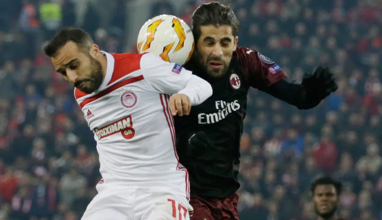 Pemain Olympiakos Piraeus, Giannis Fetfatzidis berebut bola dengan pemain AC Milan, Ricardo Rodriguez dalam laga keenam Grup F Liga Europa di Stadion Georgios Karaiskakis, Kamis (13/12). AC Milan takluk 1-3 dari Olympiacos. (AP /Thanassis Stavrakis)