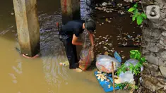 Warga kerja bakti membersihkan sampah yang terbawa aliran Kali Baru di bawah Jembatan Merah, Jalan Pitara Raya, Depok, Jawa Barat, Rabu (19/2/2020). Pascahujan deras yang terjadi sehari sebelumnya, sampah dari arah Bogor terbawa aliran Kali Baru hingga ke Depok. (merdeka.com/Magang/Muhammad Fayyadh)