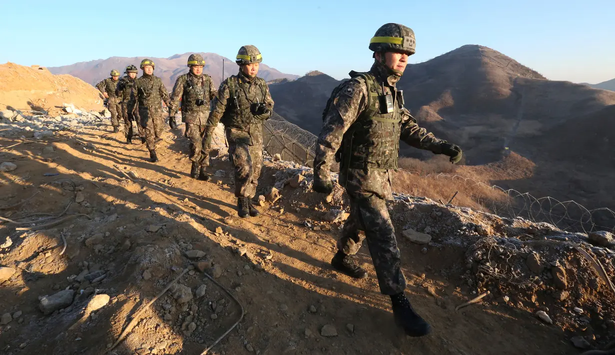 Tentara Korea Selatan menuju Korea Utara memverifikasi penghancuran pos penjaga di Zona Demiliterisasi, Rabu (12/12). Pertama kalinya, prajurit Korut dan Korsel menyebrang ke wilayah masing-masing dengan damai. (South Korea Defense Ministry via AP)