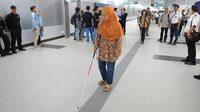 Penyandang disabilitas berjalan di guiding block usai menaiki kereta MRT di Jakarta, Kamis (21/3). Dalam kesempatan tersebut mereka dapat menikmati fasilitas yang disediakan untuk disabilitas. (Liputan6.com/Angga Yuniar)