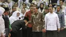 Seorang guru mencium tangan Presiden Joko Widodo (Jokowi) saat hadir dalam Peringatan Hari Guru Nasional 2015, Istora Senayan, Jakarta, Selasa (24/11). Peringatan hari guru tahun ini mengangkat tema 'Guru Mulia Karena Karya'. (Liputan6.com/Faizal Fanani)