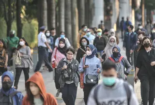 Pekerja melintas di trotoar Jalan Jenderal Sudirman saat jam pulang kantor, Selasa (4/1/2022). PPKM di Jakarta kembali diperpanjang oleh pemerintah pusat terhitung 4-17 Januari 2022 dari sebelumnya di Level 1 kini menjadi Level 2. (merdeka.com/Iqbal S. Nugroho)
