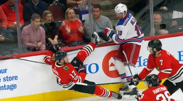 Pemain Chicago Blackhawks Lance Bouma (17) terjatuh saat berebut puck dengan pemain New York Rangers, Miller (10) saat pertandingan NHL di Chicago (15/11). Blackhawks unggul 6-3 atas Rangers. (AP/Charles Rex Arbogast)