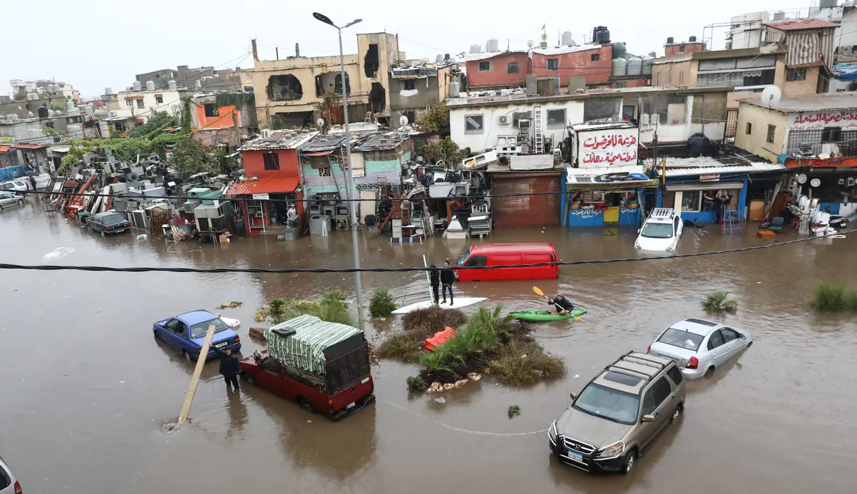 Sejumlah kendaraan mogok di jalan banjir akibat hujan deras di Beirut, Lebanon (9/12/2019). Hujan deras membuat sejumlah rumah dan kendaraan di Lebanon terendam banjir dan melumpuhkan daerah-daerah dari ibukota Beirut, Lebanon. (AFP Photo/Anwar Amro)