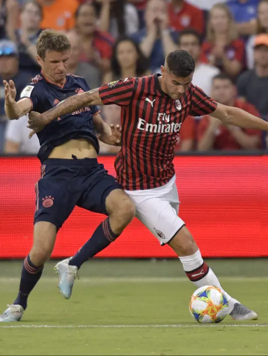 Bek baru AC Milan, Theo Hernandez menggiring bola melewati penyerang Bayern Munchen, Thomas Muller selama pertandingan ICC 2019 Di Children's Mercy Park di Kansas City (23/7/2019). Theo Hernandez dibeli Milan dari Real Madrid seharga 20 juta euro atau sekira Rp316 miliar. (AFP Photo/Tim Vizer)