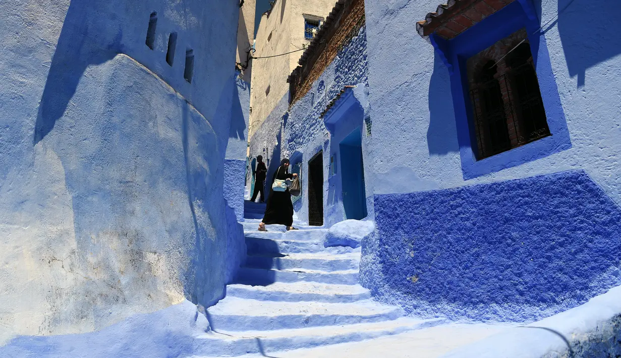 Seorang wanita berjalan di sepanjang gang kecil, Kota Chefchaouen, Maroko, Minggu (1/5). Keindahan kota Chefchaouen bahkan mengalahkan keindahan kota penuh cinta, Paris. (FADEL SENNA / AFP)
