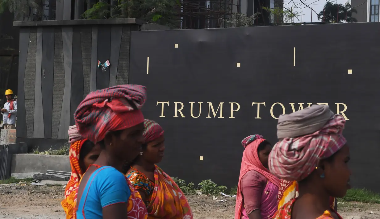 Buruh wanita India berkumpul sebelum mengangkat bata untuk pembangunan konstruksi Trump Tower atau Menara Trump di Kolkata, India (20/2). (AFP/ Dibyangshu Sarkar)
