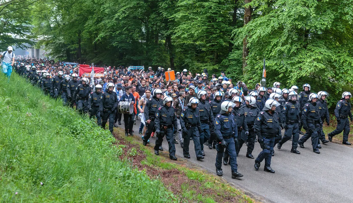 Para pendukung Olympique Marseille dikawal polisi saat menuju Red Bull Arena untuk menonton pertandingan melawan FC Salzburg di Austria (3/5). Mereka akan menonton pertandingan semi final Liga Europa. (JFK / EXPA / APA / AFP)
