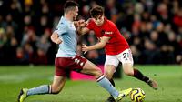 Pemain Manchester United Daniel James (kanan) berebut bola dengan pemain Aston Villa John McGinn saat bertanding pada pertandingan Liga Inggris di Old Trafford, Manchester, Inggris, Minggu (1/12/2019).  Skor berakhir 2-2. (Martin Rickett/PA via AP)